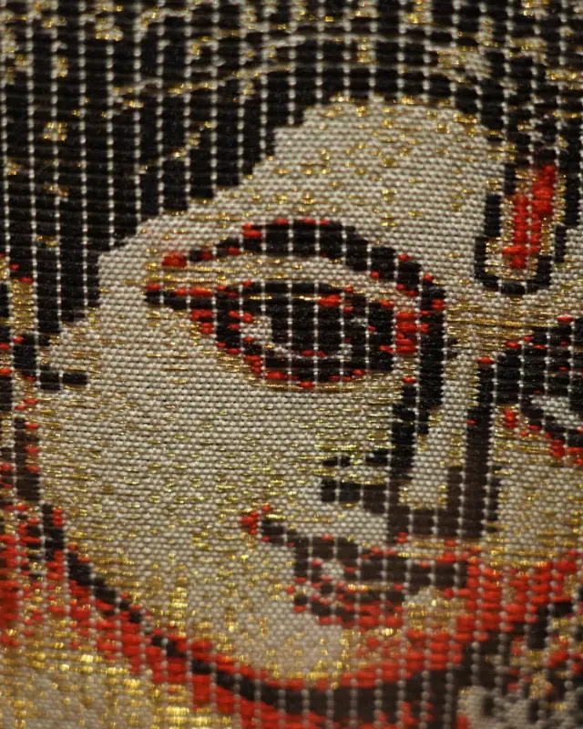 Close-up of a face woven in silk with gold zari, from the Radha Krishna artwork